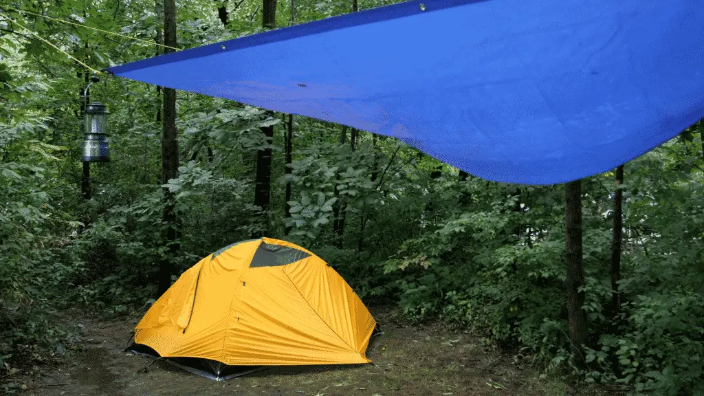 Use a tarp to create a sheltered outdoor living area to stay dry camping in the rain.