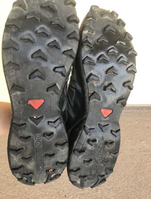 An aggressive tread pattern on the bottom of salomon trail runners. 